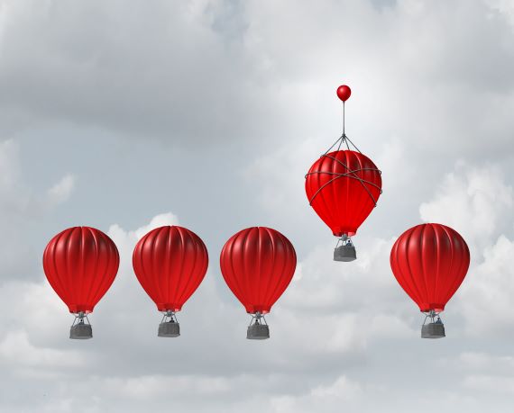 Picture of a red balloon ascending higher than others