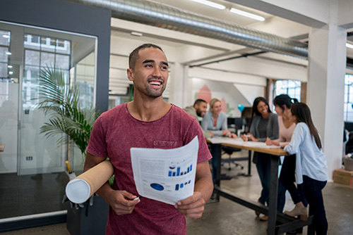 Portrait of a casual business man working at the office use te reo māori holding documents and carrying blueprints