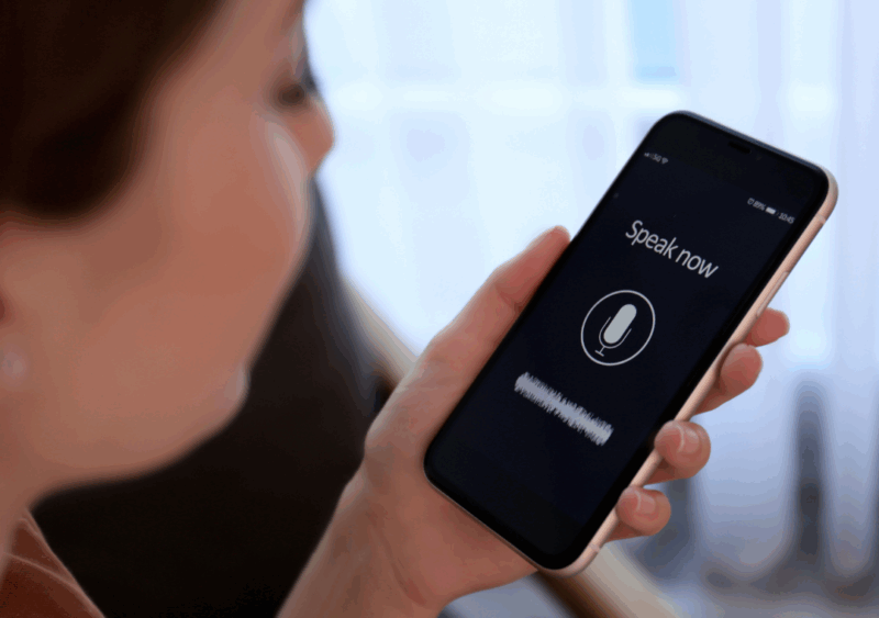 Person holding phone using the voice to text function.